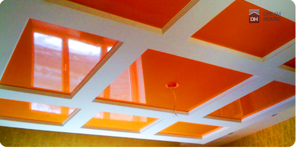Эксклюзивное дизайнерское решение. На потолке установлена гипсо-картонная конструкция с нишами для вставки натяжного потолка. Оранжевый цвет натяжного потолка подходит к белому цвету гипсо-картонной конструкции